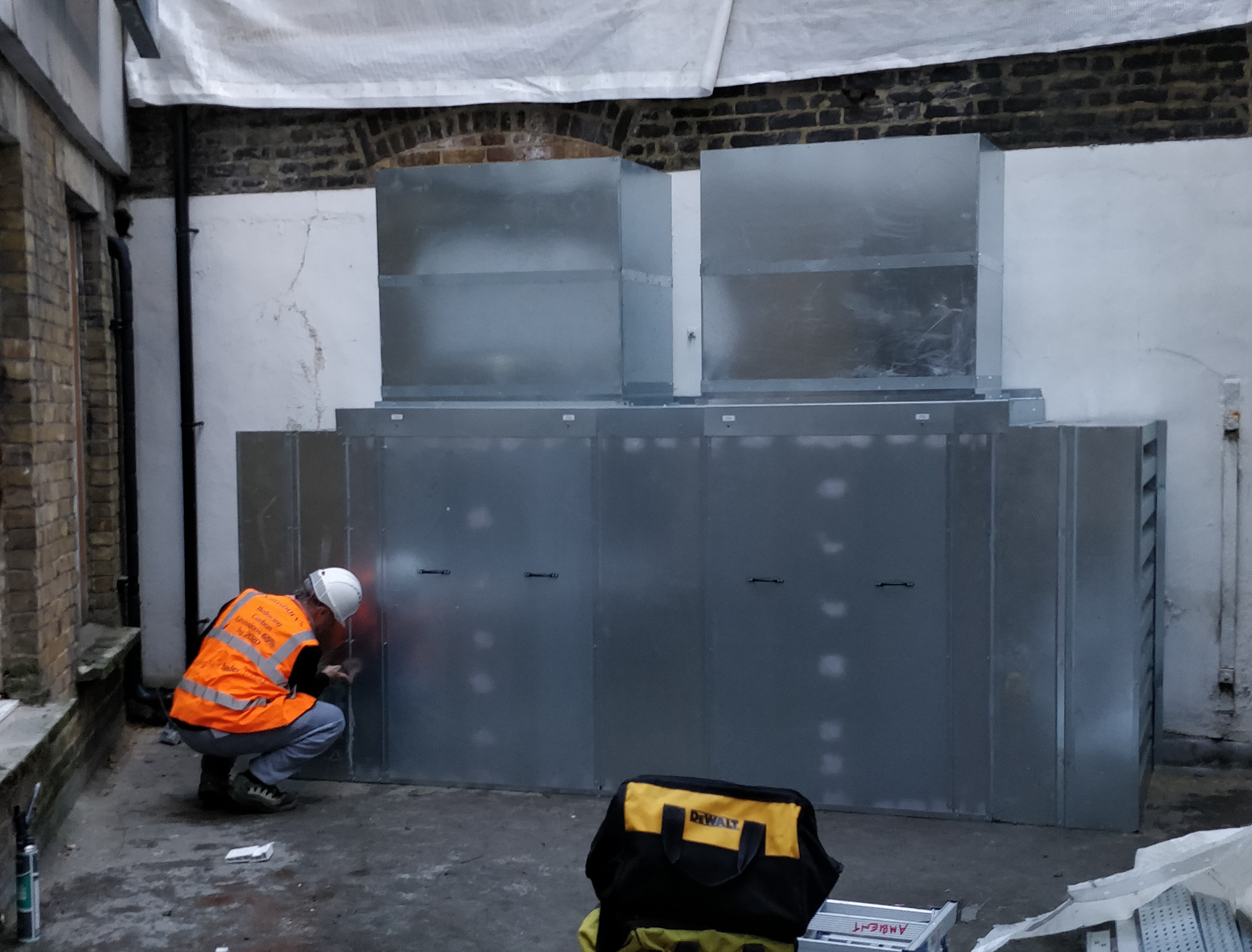 Wall-attached enclosure fitted to Mitsubishi unit